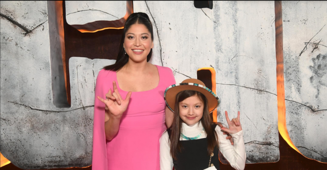 Alaqua Cox and child getting their photo taken at the Echo premier doing the ASL sign for