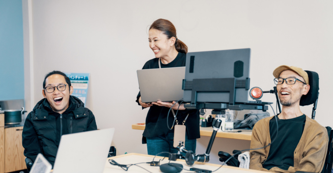 man with disability using assistive technology computer with colleges at work